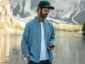 Un homme porte une chemise en tissu léger, parfaite pour une journée en plein air au bord d'un lac.