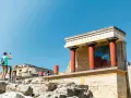 Zwiedzający robi zdjęcie fresku z bykiem w starożytnym pałacu w Knossos.