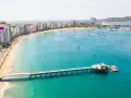 Malecón w Manta, Ekwador. Widok na plażę, budynki, molo i zatokę z łodziami. Tu właśnie leży Ekwador, kraj na równiku.