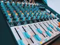 Console de mixage audio avec de nombreux boutons et curseurs. Les niveaux de volume peuvent être ajustés pour un son parfait, peut-être jusqu'à 40 décibels.