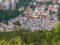 Widok z góry na gęsto zabudowaną fawelę w Brazylii, otoczoną zielenią. Czy Brazylia jest bezpieczna? To pytanie nurtuje wielu turystów.