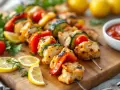 Délicieuses brochettes de poulet grillées avec des légumes colorés, des quartiers de citron et une sauce tomate.