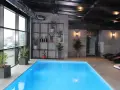 Nowoczesny hotel spa Białystok z basenem, jacuzzi i leżakami. Duże okna z widokiem na miasto.