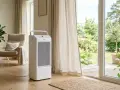 Climatizador blanco en salón moderno, mostrando la diferencia entre aire acondicionado y climatizador.