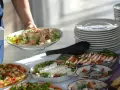 Na stole bufetowym z pizzą, sałatkami i śledziami, dowiedz się, jakie są zasady korzystania z "open baru" i bufetów tematycznych.