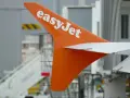 Pomarańczowe usterzenie EasyJet z białym logo, gotowe do lotu. Sprawdź wymiary bagażu podręcznego przed podróżą.