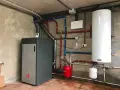 Instalación de caldera de pellets para radiadores, con depósito de agua caliente y sistema de tuberías.