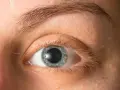 Occhio con iride azzurra e pupille dilatate, forse per l'emozione o la poca luce.
