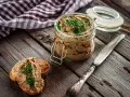 Un tarro de rillettes, paté de cerdo desmenuzado, con eneldo fresco, servido sobre pan tostado.