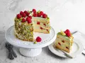 Wyjątkowy tort pistacjowy z malinami i limonką, ozdobiony chrupiącymi pistacjami. Idealny na każdą okazję.
