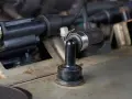 A black rubber PCV valve hose connected to a metal engine component. This part can cause bad PCV valve symptoms if it fails.
