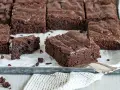 Saftige Schokoladen-Brownies, perfekt für jedes Brownie Rezept. Ein Stück wird gerade herausgehoben.