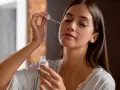 Kobieta aplikuje serum z kwasem niacynamid na twarz. Delikatna pielęgnacja dla promiennej cery.