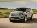 Szary Land Rover Discovery Sport w ruchu, z widocznym napisem "DISCOVERY". Czyżby kolejne awarie?