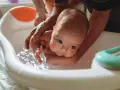 Delikatne kąpiel noworodka w wanience. Czy przy gorączce można kąpać dziecko? Tak, ale w letniej wodzie.