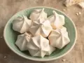 Ein Teller voller zarter Baiser, perfekt für jedes Baiser Rezept. Sie sehen aus, als wären sie frisch aus dem Ofen und bereit, auf der Zunge zu zergehen.