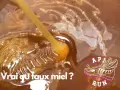 Goutte de miel cru bio, onctueux et doré, tombant dans un pot. Le texte "Vrai ou faux miel ?" interroge sur son authenticité.