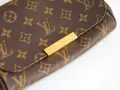 Zbliżenie na brązową torebkę Louis Vuitton z monogramem i złotym zapięciem.