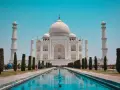 El Taj Mahal, en Agra, India, se alza majestuoso con su cúpula blanca y minaretes, reflejado en el estanque.