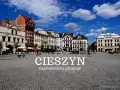 Cieszyn rynek z kolorowymi kamienicami i błękitnym niebem. Spacer po brukowanym placu, gdzie widać ludzi i ławki.