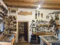 Wnętrze muzeum historii Bieszczad. Eksponaty to narzędzia, broń, siodła i przedmioty codziennego użytku.