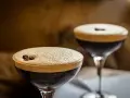 Dwa drinki z pianką i ziarnami kawy. Wybór między Espresso Martini a Irish Coffee.
