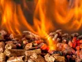 Fiamme arancioni danzano su un letto di pellet ardente. Per scaldare 100 mq, quanti kw servono?