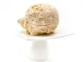 Eine Kugel Milchreis Eis auf einem weißen Teller. Cremig und mit Stückchen, ein Genuss!