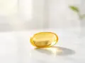 Capsula gialla di vitamina D3 su marmo. La vitamina D3 serve per ossa forti e sistema immunitario.