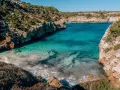 Cala des Moro, Majorka. Turkusowa woda obmywa skaliste wybrzeże, tworząc malowniczą zatoczkę.