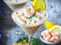 Ein cremiger Shrimp Cocktail in einem Martiniglas, garniert mit Dill und Zitrone. Ein köstlicher Genuss!