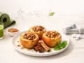 Zdrowe pieczone jabłka dietetyczne z orzechami i cynamonem, obok zielonego smoothie, maty do ćwiczeń i hantli.