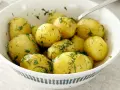 Proste dania z gotowanych ziemniaków przepis: młode ziemniaki z koperkiem w białej misce, gotowe do podania.