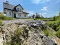 Nieaktywne osuwisko obok budowy domu. Teren niestabilny, droga częściowo zniszczona.