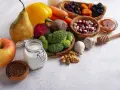 Składniki na zdrową dietę jelitową: jabłko, gruszka, brokuły, buraki, marchew, papryka, fasola, orzechy, czosnek, siemię lniane, jogurt, suszone owoce i miód.