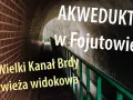 Wielki Kanał Brdy w Fojutowie, imponujący akwedukt w tunelu z cegły, z zieloną balustradą i widokiem na las.