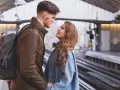 Un couple se regarde avec tendresse sur un quai de gare, un moment où l'on peut se sentir connecté à quelqu'un à distance.
