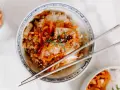 Miseczka ryżu z pikantnym kimchi i marchewką, idealne połączenie. Pałeczki czekają, by zacząć jeść.