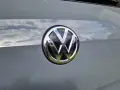 Das VW-Logo auf dem Heck eines grauen Autos. Eine Erklärung zum Fahrzeugdatenträger VW ist hier nicht ersichtlich.