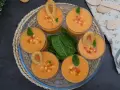 Gazpacho de mango en vasos con trocitos de mango, menta y picos.