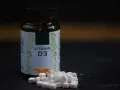 Flasche mit Vitamin D3 und Tabletten. Wann einnehmen? Informieren Sie sich über die beste Einnahmezeit für Ihr Wohlbefinden.