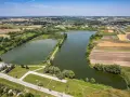 Krajobraz z lotu ptaka ukazuje malownicze wzgórza krzesławickie, jeziora, pola uprawne i zabudowania.
