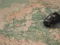 Czarny samochodzik na mapie Europy. Przygotuj się na podróż, sprawdź, co trzeba zabrać na przegląd samochodu.