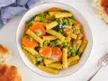 Makaron z mlekiem kokosowym i curry, z marchewką i groszkiem. Kremowy sos otula złociste rurki, tworząc aromatyczne danie.