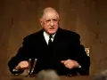 Charles de Gaulle, en costume sombre, s'exprime avec passion. Sa stature imposante et son regard déterminé marquent l'histoire.