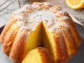 Una fetta di torta all'arancia morbidissima, cosparsa di zucchero a velo, pronta per essere gustata.