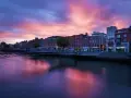 Zachód słońca nad rzeką Liffey w Dublinie. Widok na most i zabytkowe kamienice, idealne miejsce, by zobaczyć Dublin.