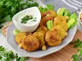 Pyszny falafel przepis na talerzu, podany z sosem jogurtowym, selerem i natką pietruszki. Idealna przekąska!