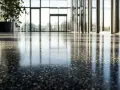 Reflejos en un suelo de terrazo pulido, ideal para modernizar espacios con un toque elegante y duradero.