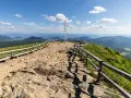 Na szczycie Tarnicy, najwyższego szczytu w Bieszczadach, stoi metalowy krzyż. Wokół kamienista ścieżka i drewniane ławki.
